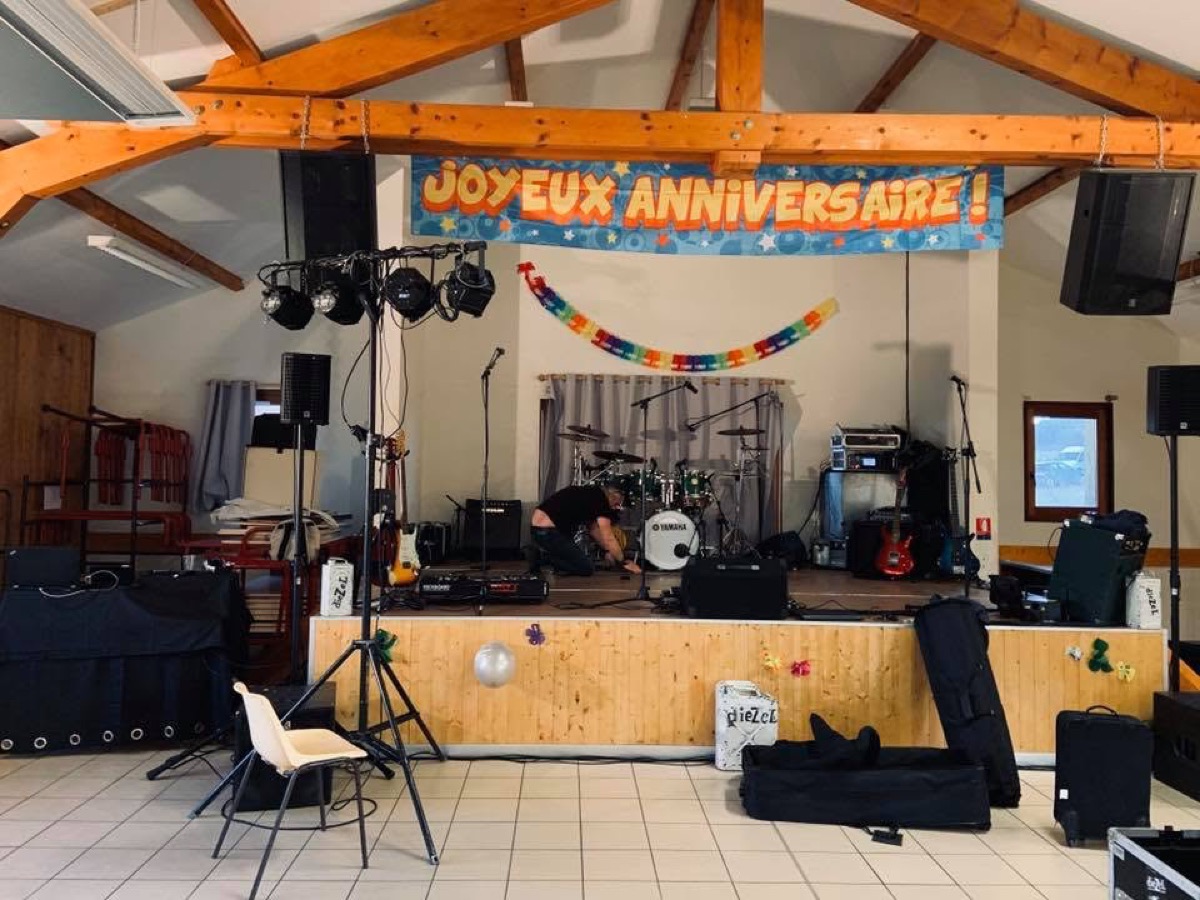 Batterie, guitares, enceintes et projecteurs installés pour un concert de Diezel lors d’un anniversaire en Haute-Loire.