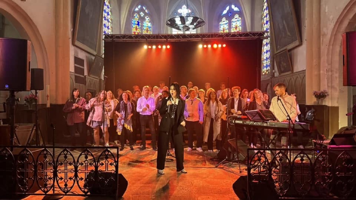 Chorale Sounds Of Gospel et musiciens sur une scène éclairée dans l’église de Châteldon.