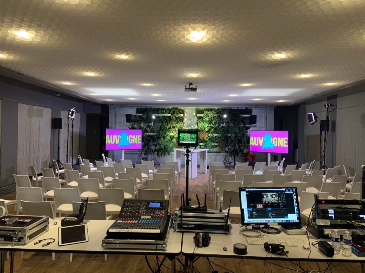 Régie son et vidéo avec console, écrans et micros pour un séminaire à Vulcania.